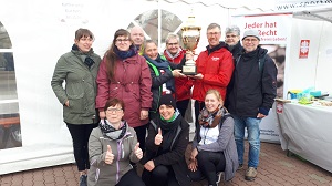 Caritasdirektor Wolfgang Langer mit dem Pokal (Bildmitte) im Kreis der Caritasmitarbeitenden