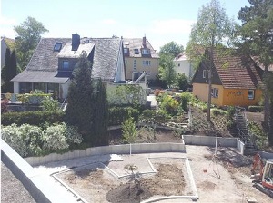 Ein Bild der Baustelle in der Sonne - die ersten Bäumchen sind gepflanzt.