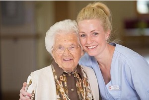 Pflegerin mit Seniorin 
