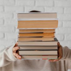 Hände halten Bücherstapel