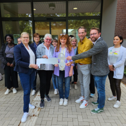 Menschen halten einen aus Papier gebastelten Schlüssel in der Hand
